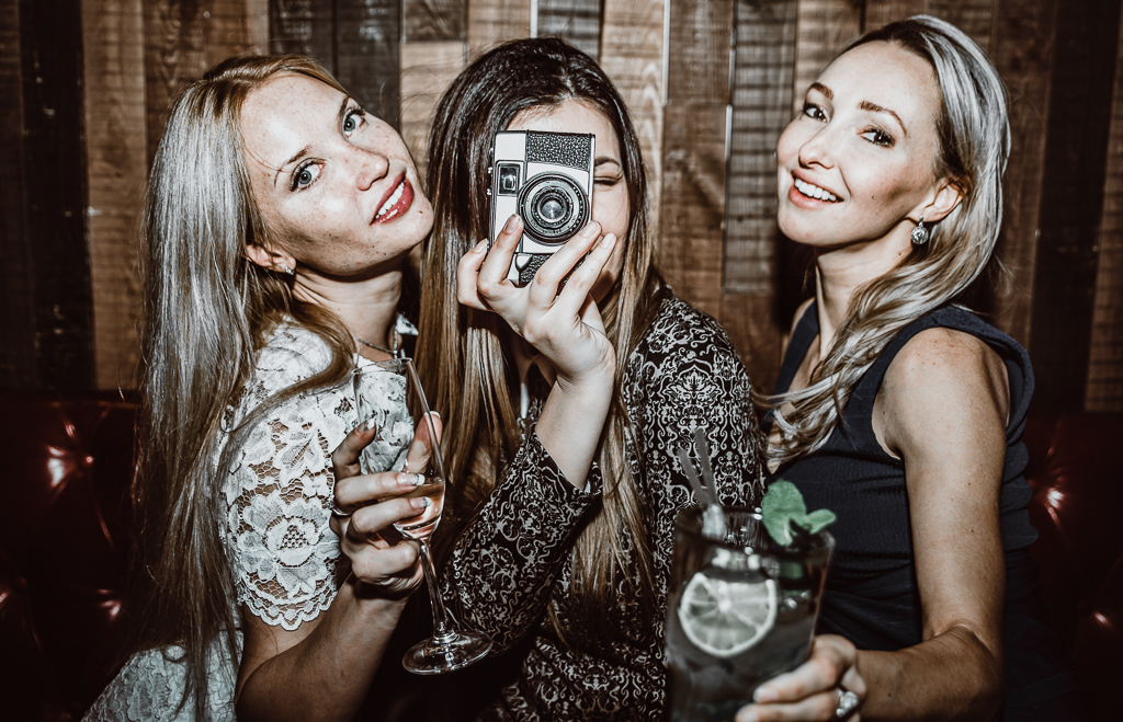 Party girls in a restaurant celebrating with drinks and champagne